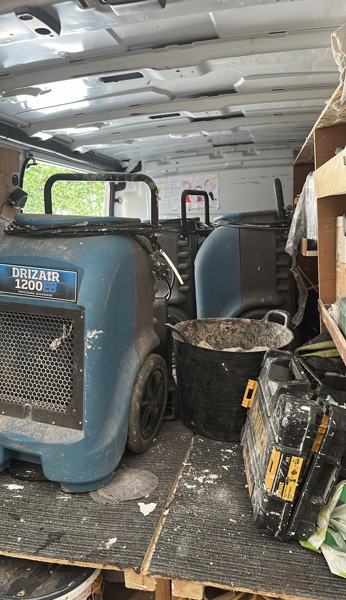 Professional dehumidifiers and drying equipment loaded for transport.